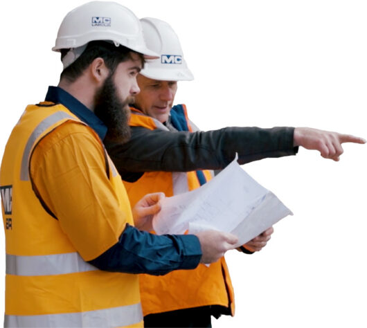 Two MC Labour workers reading plans and pointing